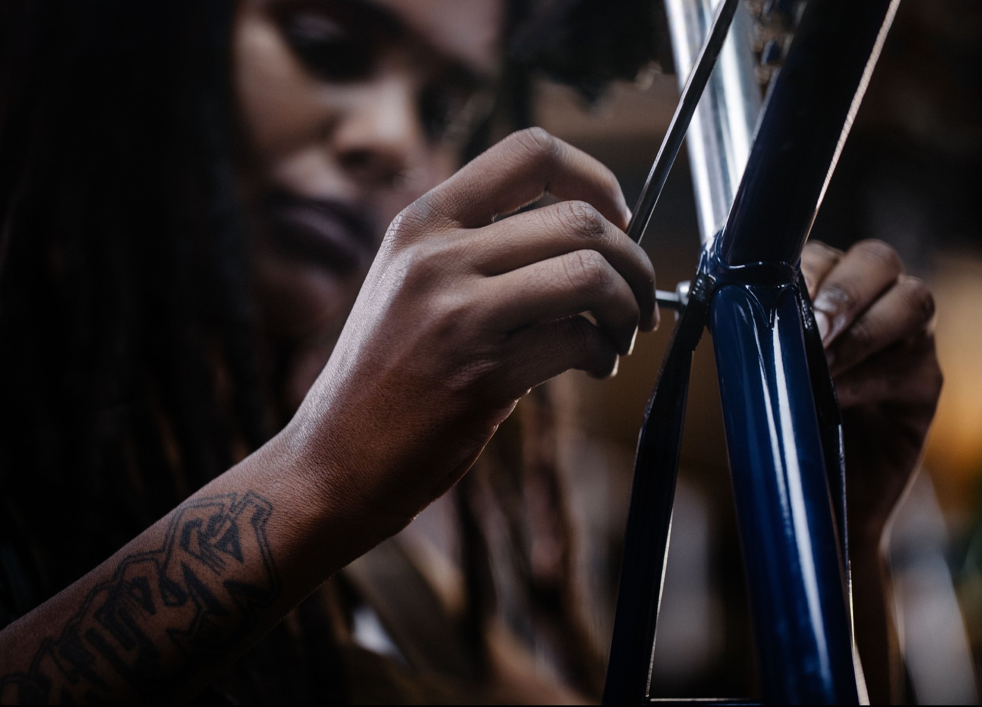 Hands of a craftsperson repairing a component on a bicycle